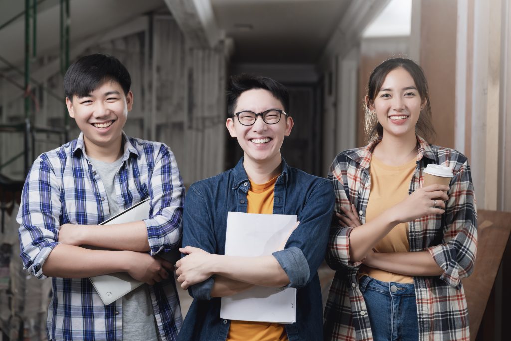 3 mahasiswa yang sedang berfoto bersama dan saling bekerja sama dalam membangun karir.